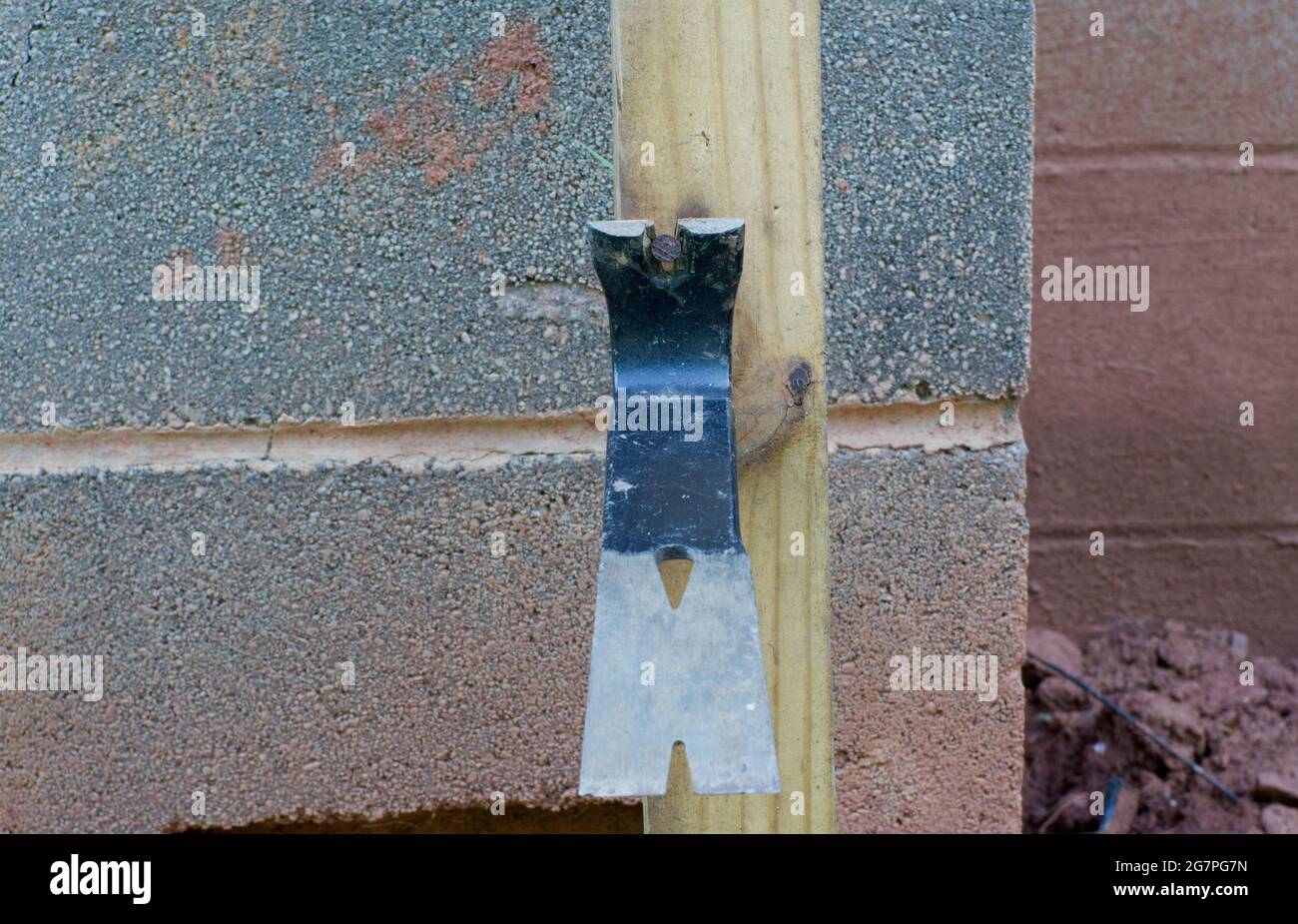 A Pry Bar Removing a Rusty Nail in a Piece of Wood to be Used Again Stock Photo