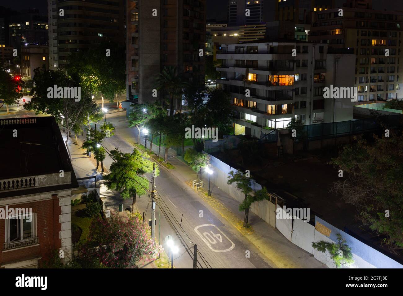 Empty roads at night view from top in Santiago city, Chile. Residential buildings and illuminated streets with trees. Quarantine, lockdown concepts Stock Photo
