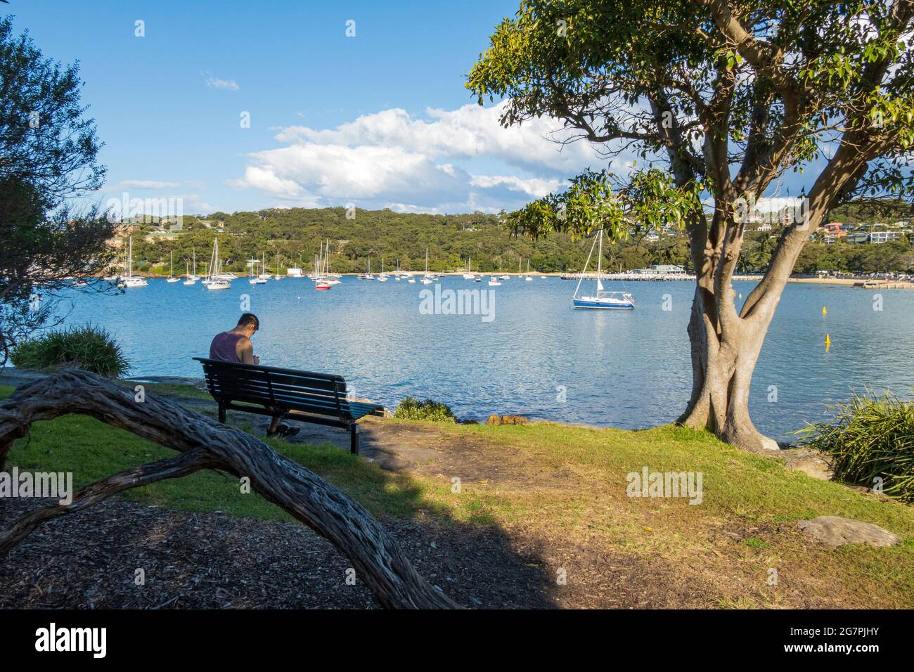 Man sitting and relaxing on a sunny day at Balmoral Beach, Sydney, Australia, during the pandemic lockdown Stock Photo
