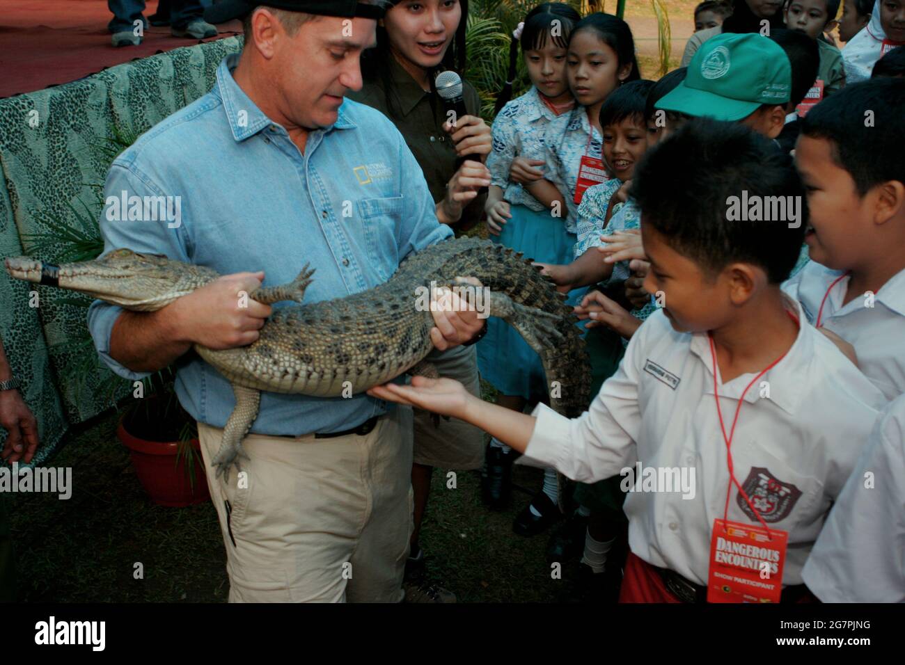 Bogor, West Java, Indonesia. 26th July 2006. Herpetologist Brady Barr is  holding a young crocodile to allow children to touch the reptile, during an  event to promote "Dangerous Encounters: Brady's Croc Adventure",