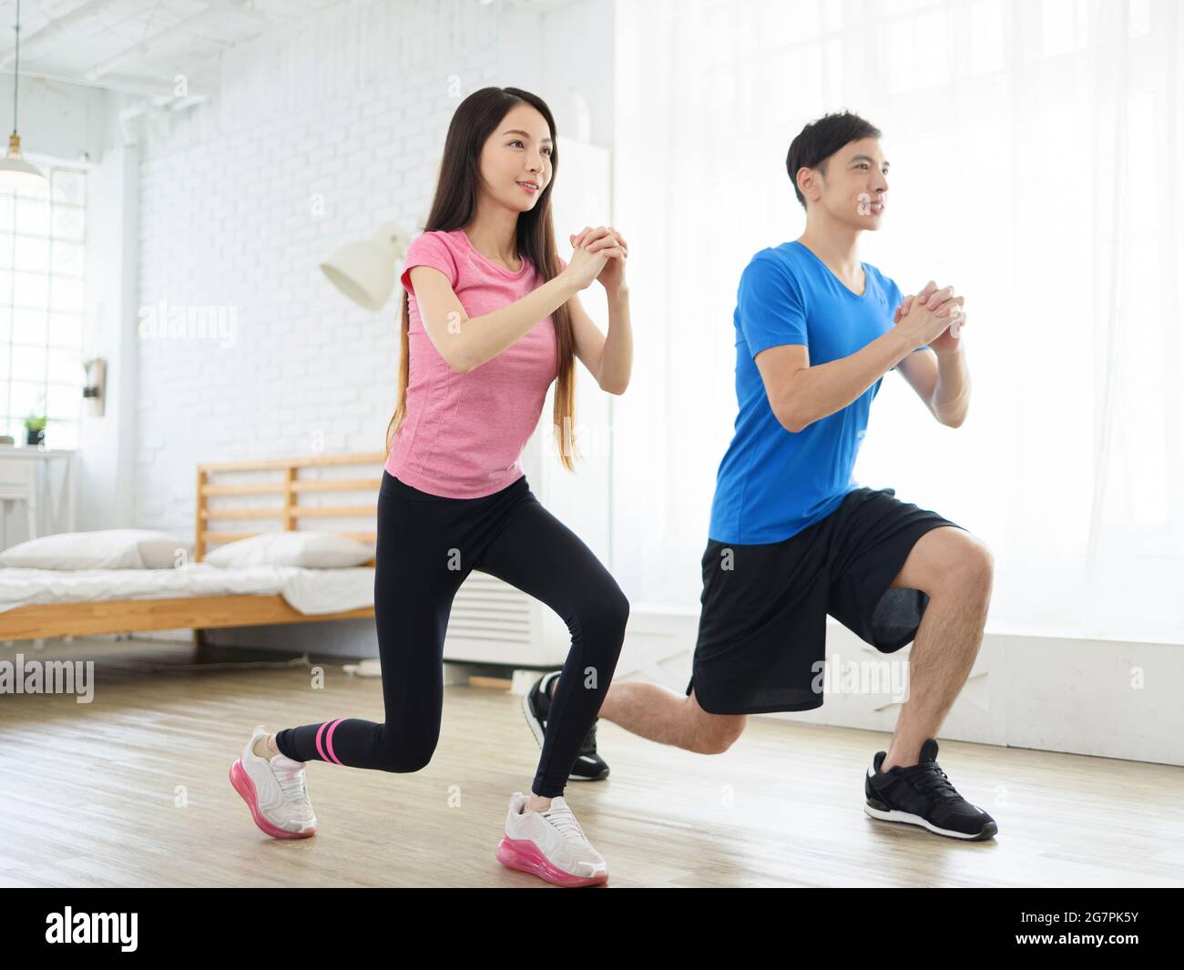 Young couple is doing fitness training at home. Stock Photo