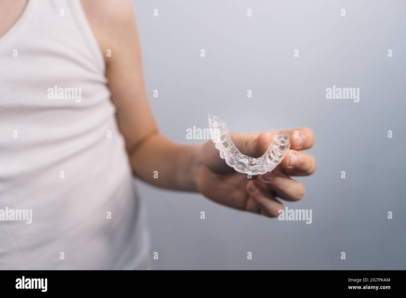Male caucasian kid with sleeveless shirt holding a mouthguard Stock Photo