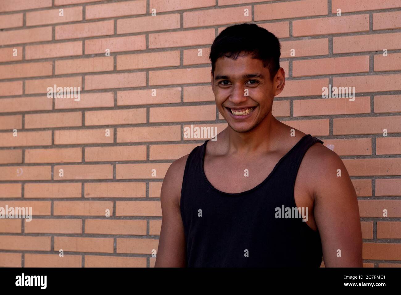 Portrait of a serious sportsman of Latino origin wearing a black tank top  on the wall background Stock Photo - Alamy