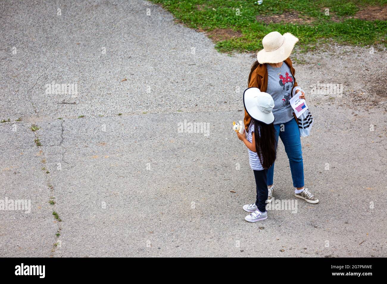 A woman and her daughter or granddaughter look opposite directions while wearing similar hats. Stock Photo