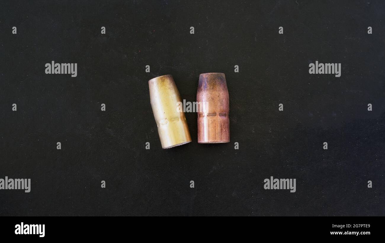 Two Used MIG Gun Welding Nozzles on a Black Background Stock Photo