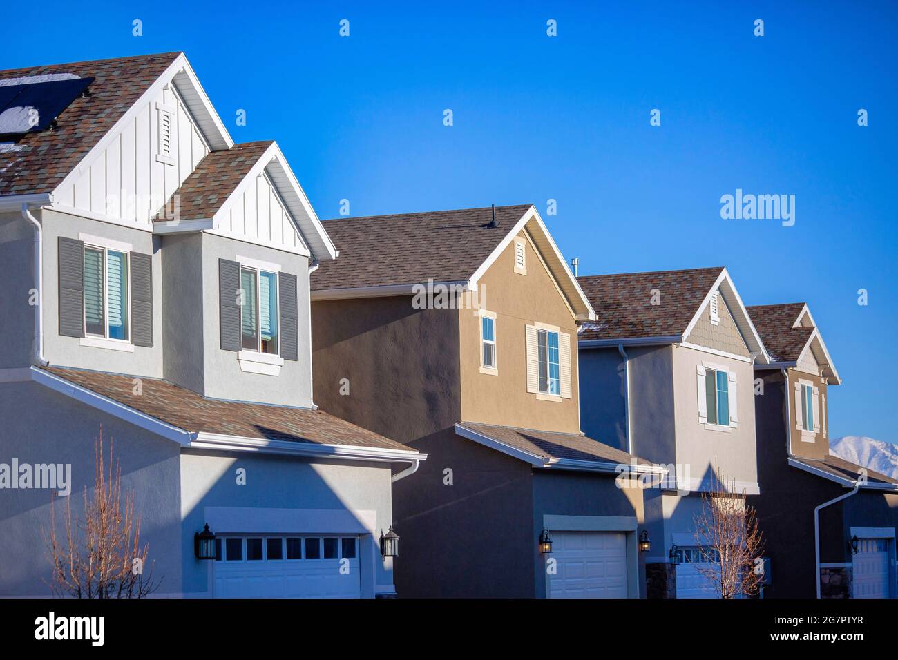 Four modern houses in a row under blue sky Stock Photo - Alamy