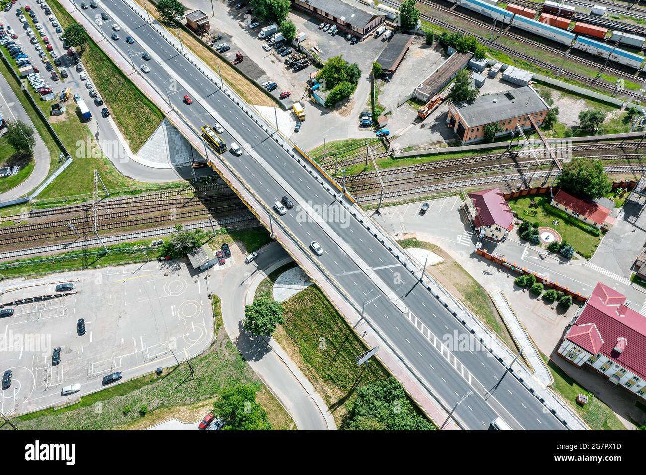 aerial view of road bridge and rail tracks. road intersection in urban industrial district. Stock Photo