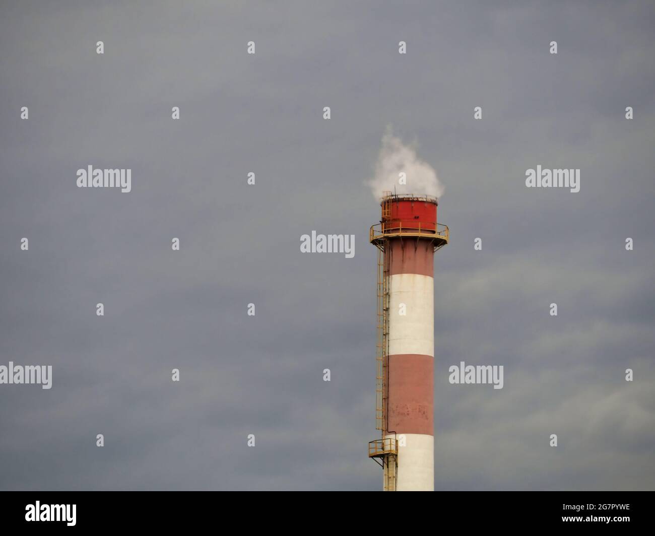 Smoke coming out of an industrial pipe against a gloomy sky Stock Photo