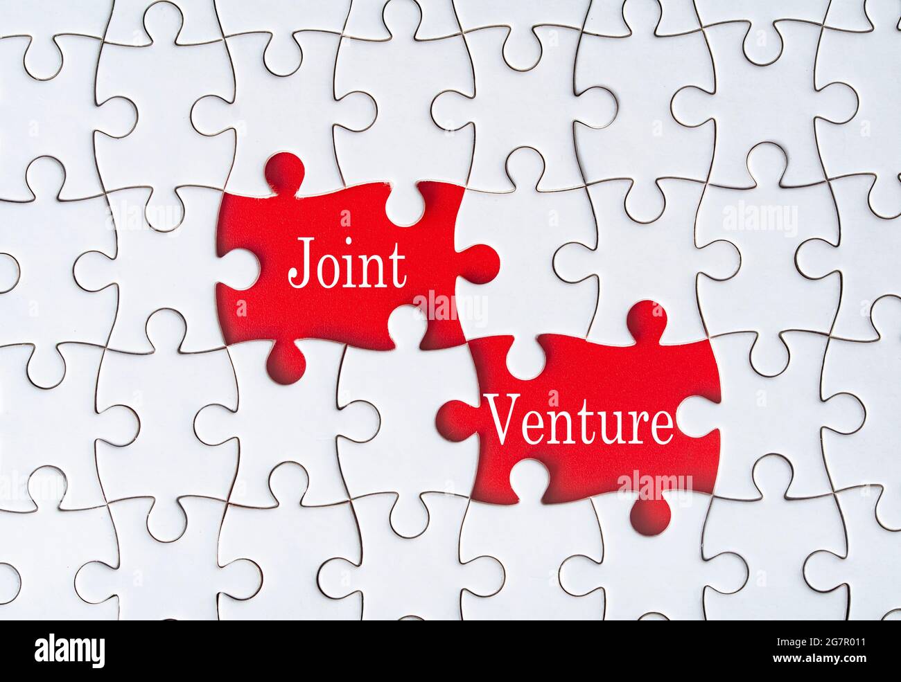 Business concept. Jigsaw puzzle with text joint venture on red background. Selective focus point Stock Photo
