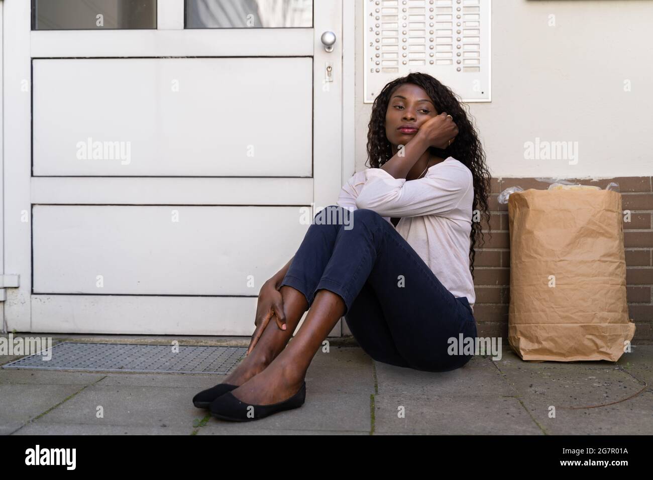 African Woman Waiting In Front Of Closed Door Stock Photo