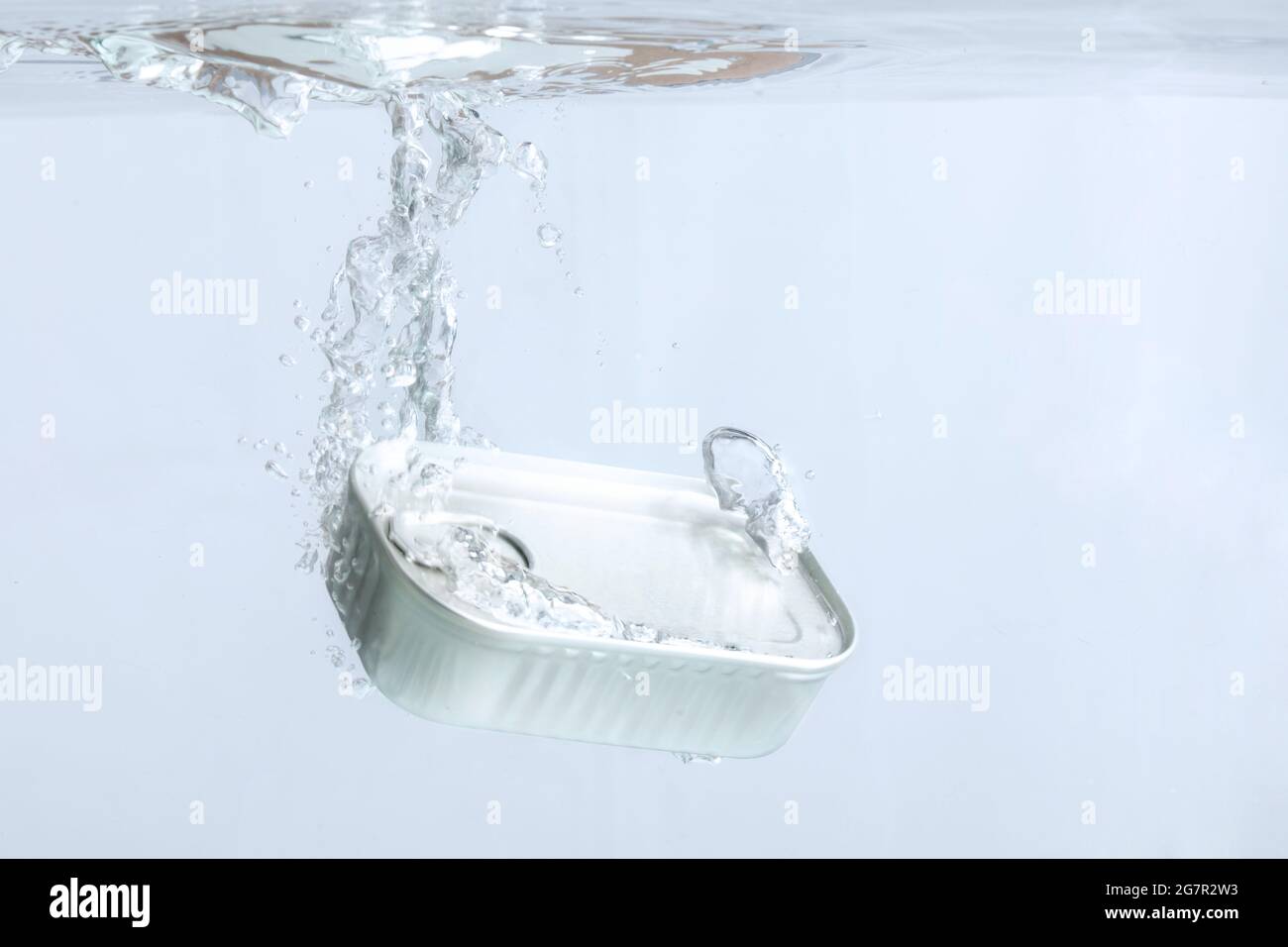 Can of sardines falling in the water on a light background Stock Photo