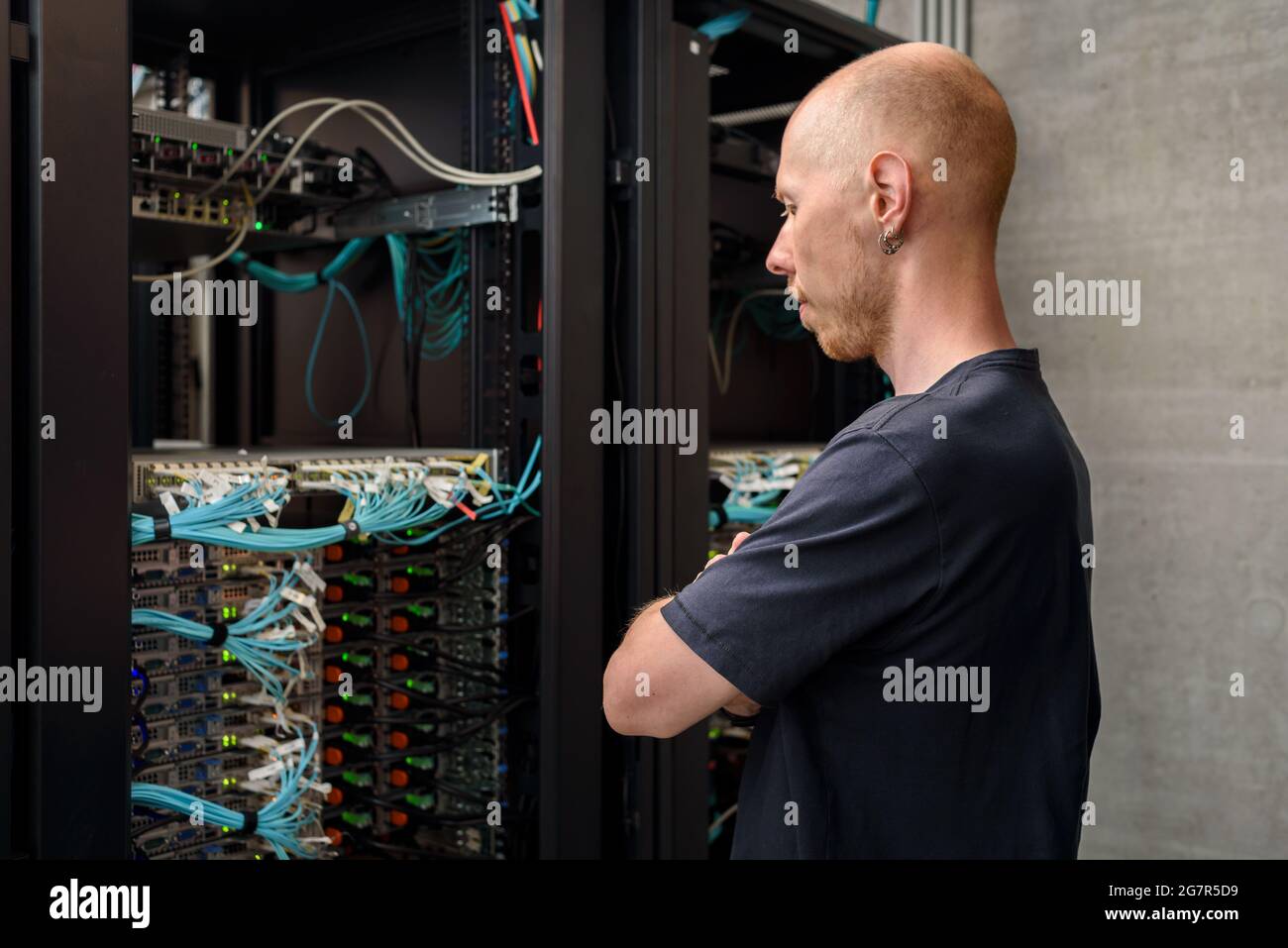 Man data center technician performing server maintenance. Looking to hardware rack Stock Photo
