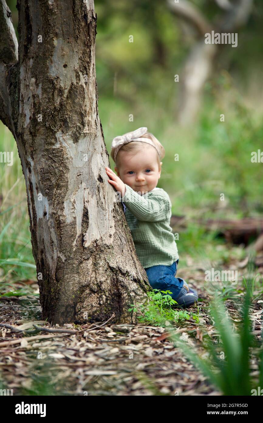 Australian kid hiding behind a tree Stock Photo - Alamy