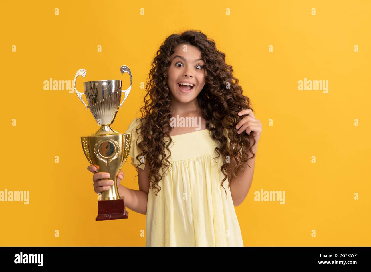 surprised kid holding golden champion cup as winner, award Stock Photo