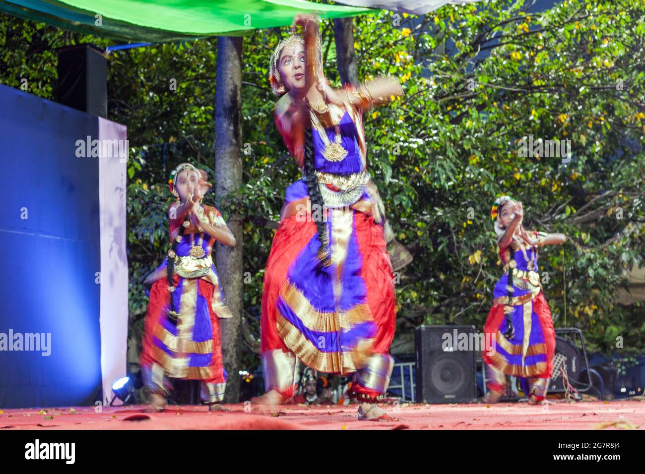 Young female Indian classical dancers in colourful costumes perform on stage, Fort Kochi (Cochin), Kerala, India Stock Photo