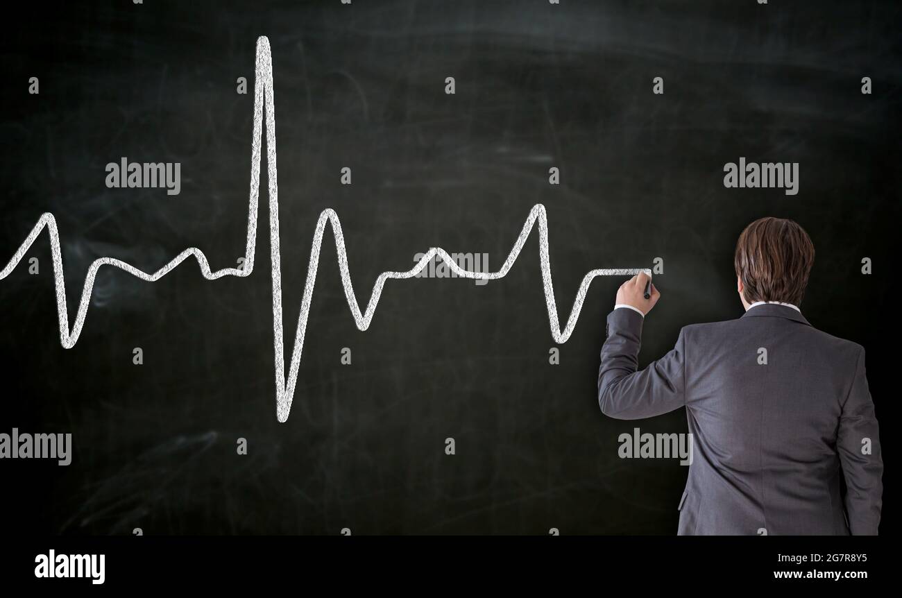 Heartbeat is painted on blackboard by businessman Stock Photo