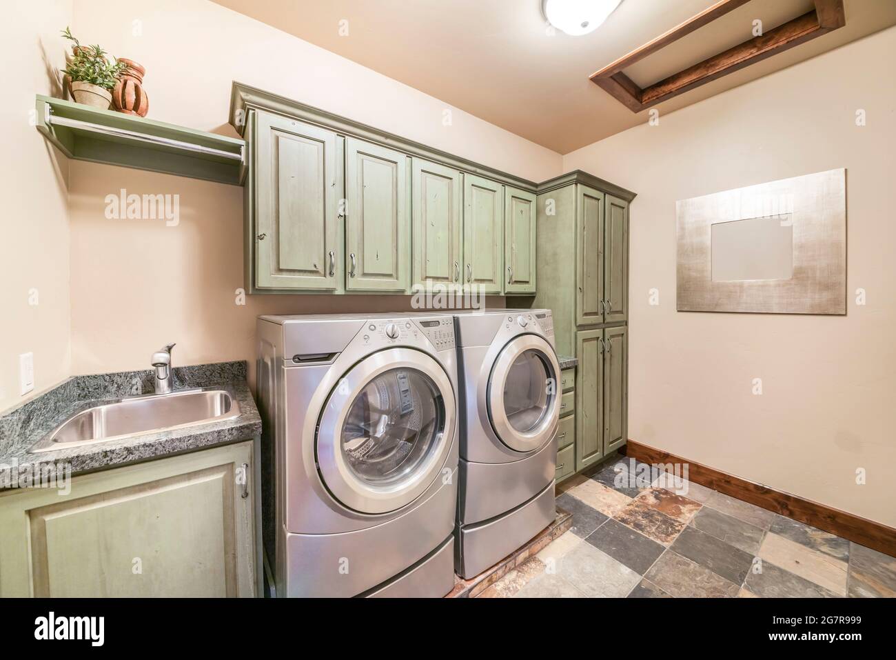 Laundry room interior with mint green and front load laundry