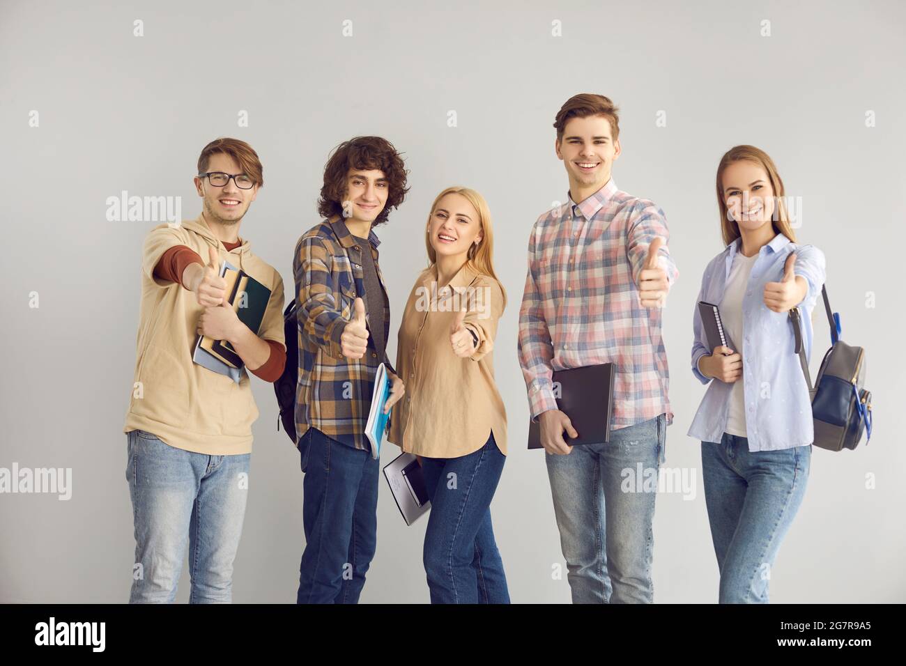 Happy student group showing thumbs up looking to camera approve school course Stock Photo