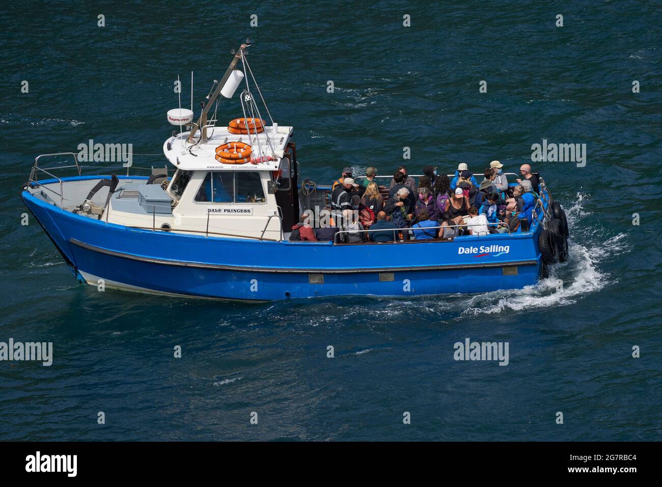 Boat filled with visitors departing from the small harbour of Martin's