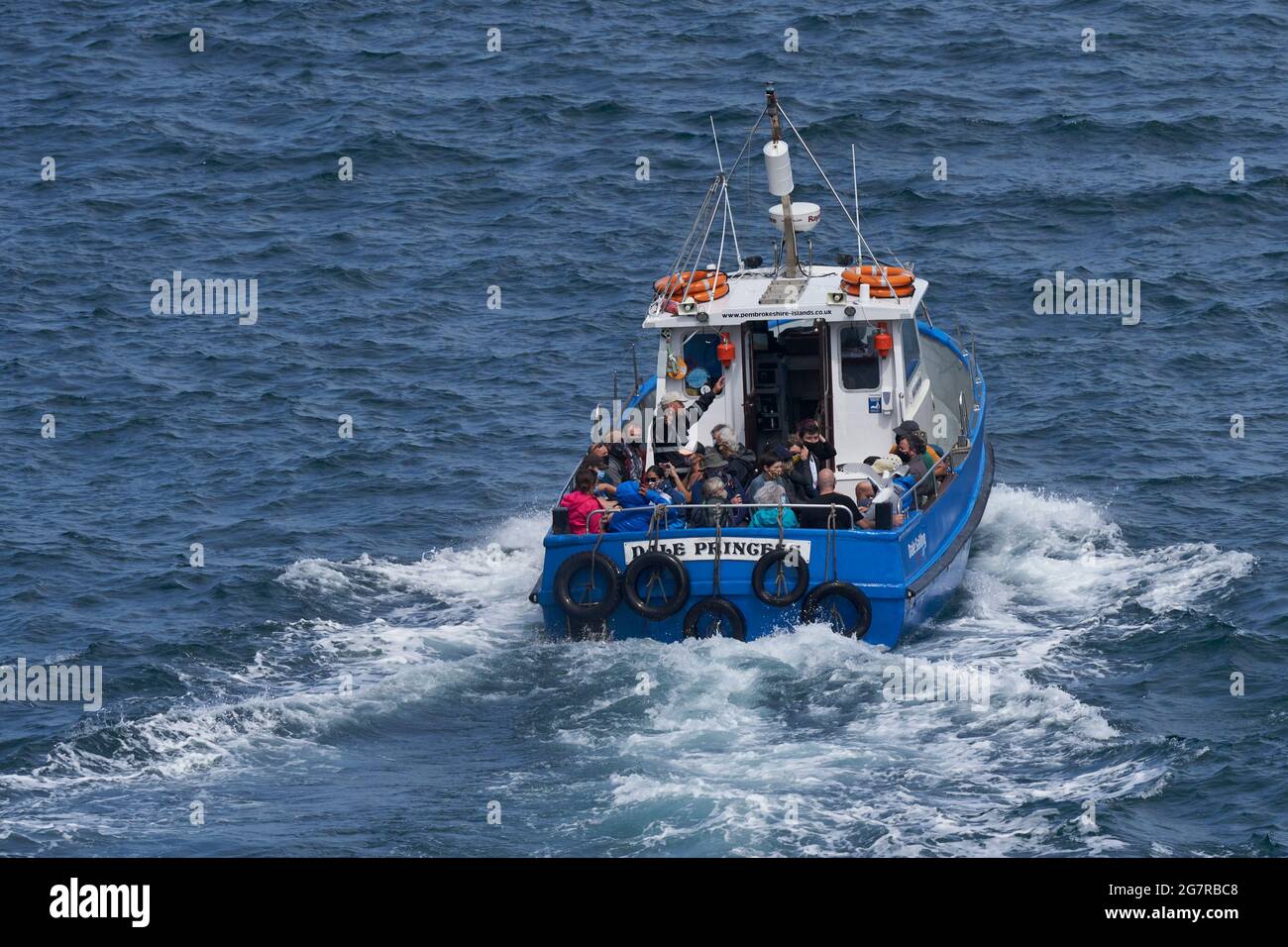 Boat filled with visitors departing from the small harbour of Martin's ...