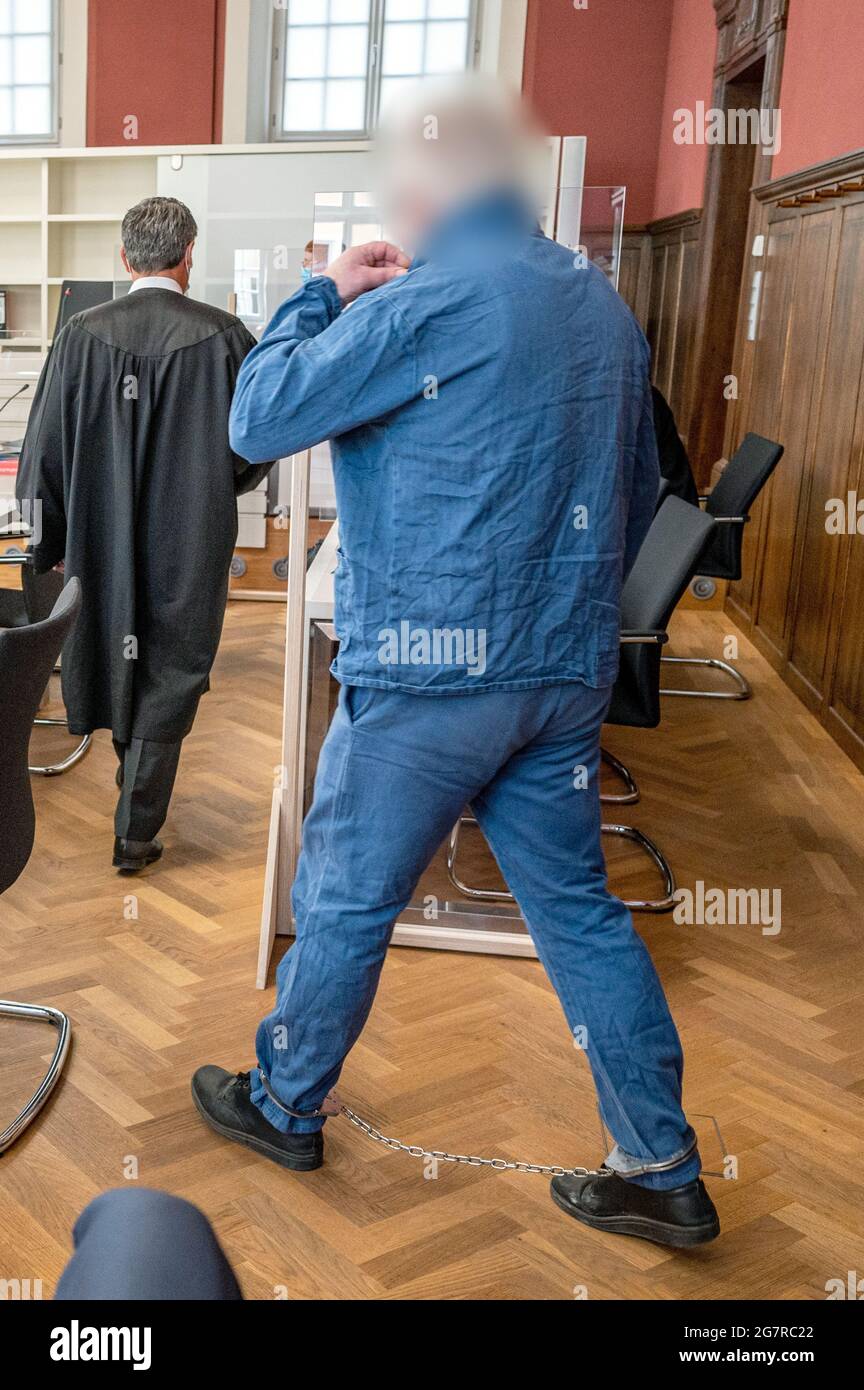 Amberg, Germany. 16th July, 2021. The defendant enters the courtroom of the district court with shackles on his feet. About one year after the violent death of a couple in Schwandorf, the man has to answer to the court. The prosecution accuses the ex-life partner of the killed woman of two counts of murder. Credit: Armin Weigel/dpa - ATTENTION: Person(s) have been pixelated for legal reasons/dpa/Alamy Live News Stock Photo