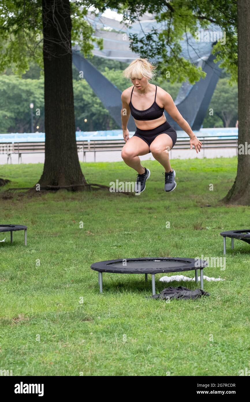 A fit woman jumping from her trampoline at an urban rebounding workout class in Queens, new York City Stock Photo