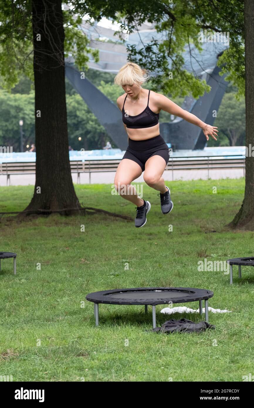 A fit woman jumping from her trampoline at an urban rebounding workout class in Queens, new York City Stock Photo