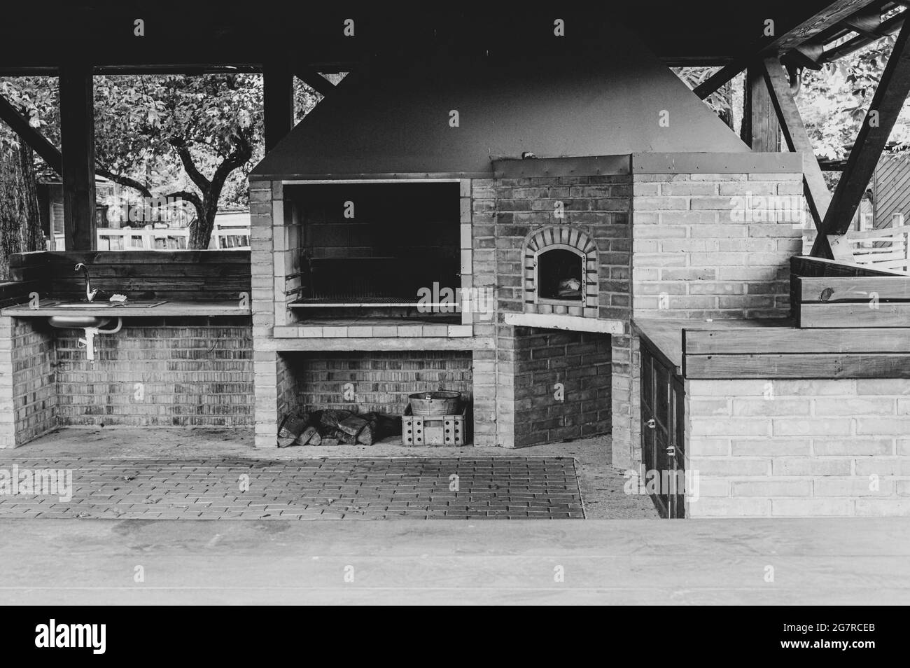 Grayscale shot of a shed in Slovakia with an oven, a fireplace and a sink Stock Photo