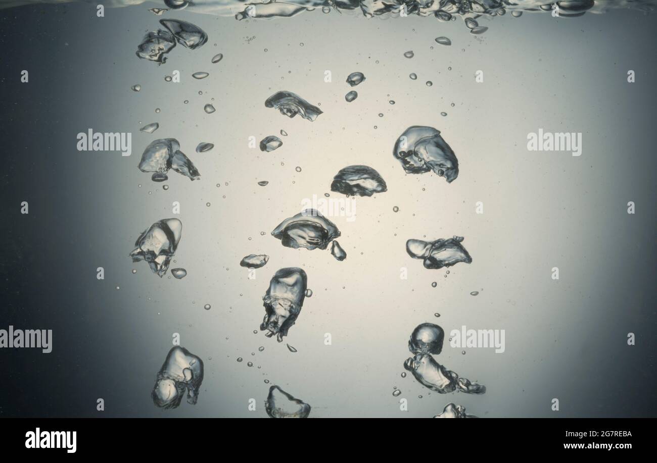 Bubbles of air rising through clear water Stock Photo