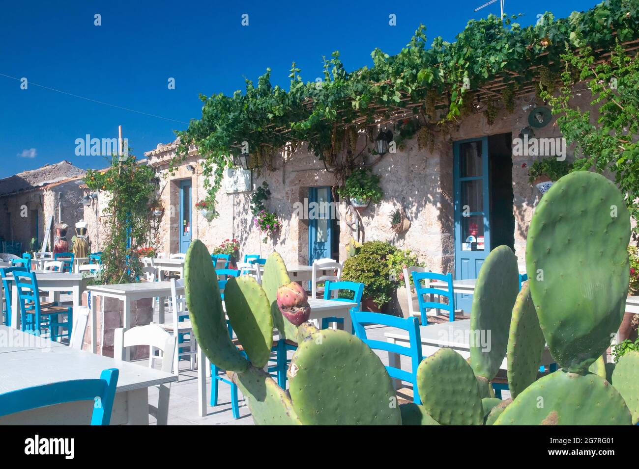 Colouful tables and chairs in the Piazza Regina Margherita in fishing hamlet of Marzamemi, Sicily Stock Photo