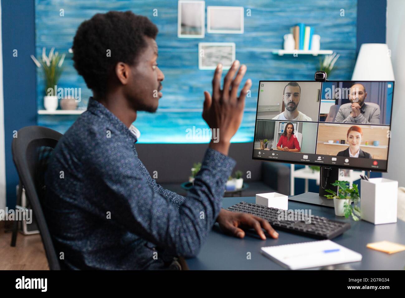 African american man talking on online video call waving to colleagues ...