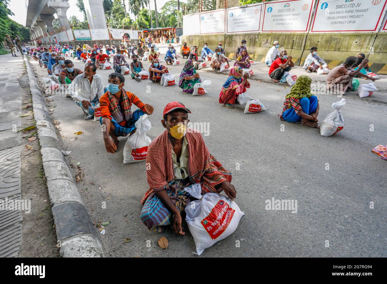 Low income people receive emergency food items provided by Bangladesh Army during the nationwide lockdown to curb the spread of coronavirus (COVID-19) Stock Photo