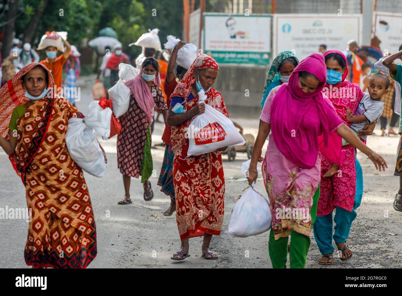 Low income people receive emergency food items provided by Bangladesh Army during the nationwide lockdown to curb the spread of coronavirus (COVID-19) Stock Photo