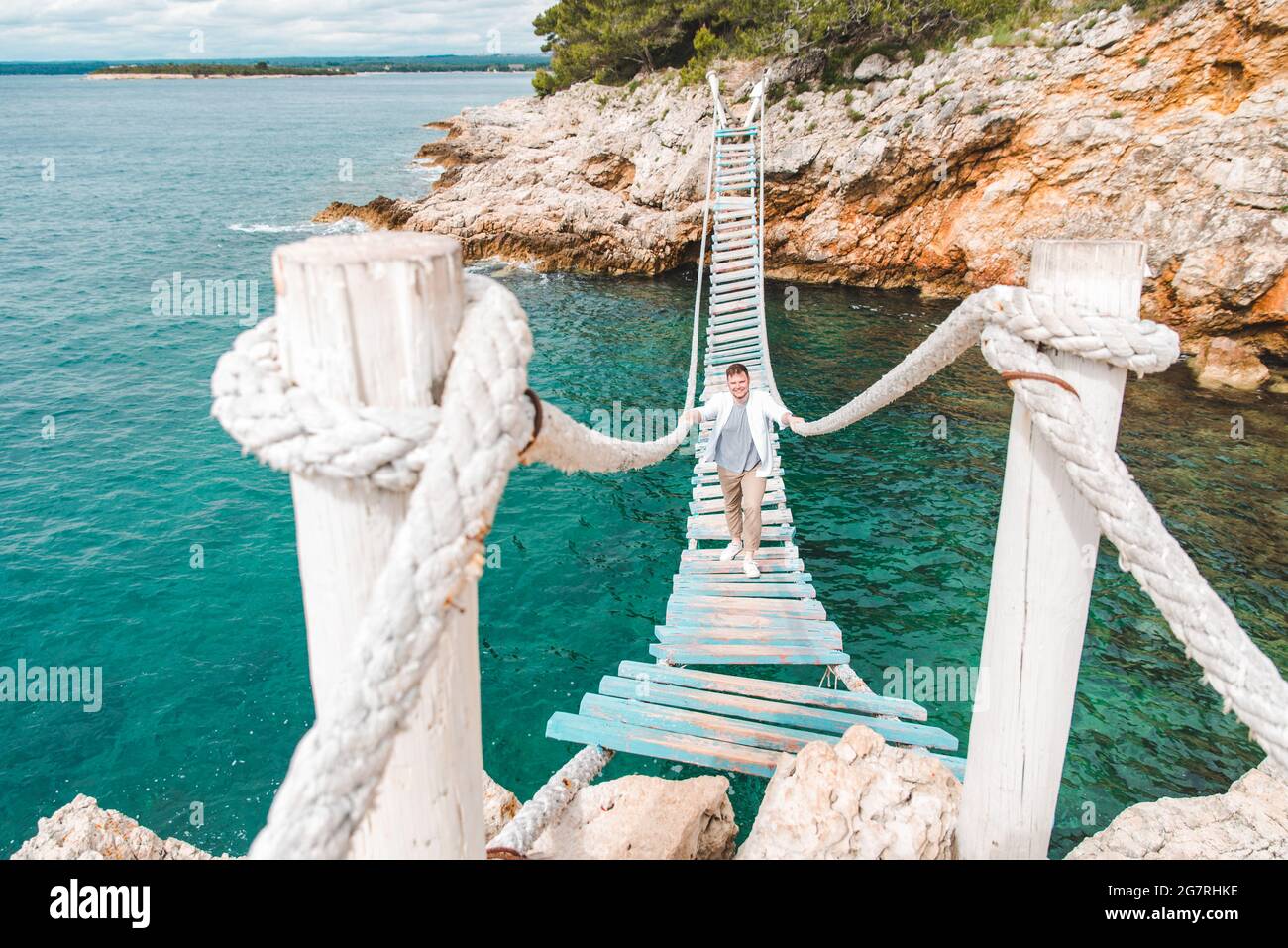 man walking by suspension bridge summer time copy space Stock Photo - Alamy