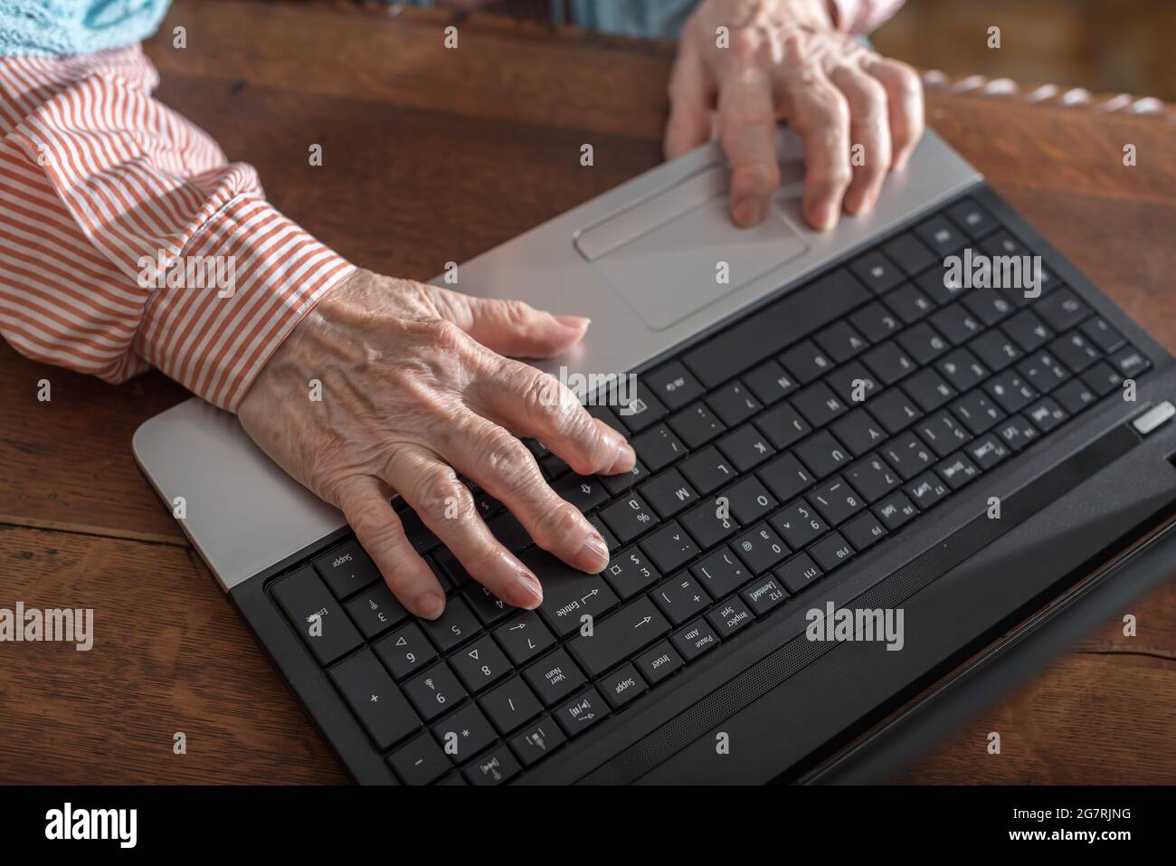 Old woman hands typing on a laptop keyboard Stock Photo - Alamy