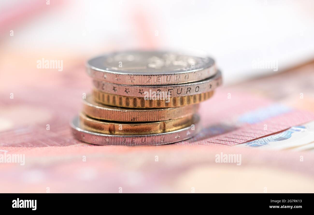 Stack of coins on euro banknotes background Stock Photo - Alamy