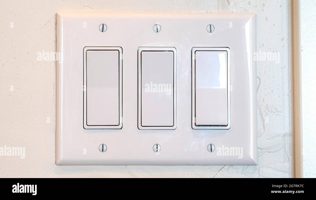 Pano Rocker light switch with multiple flat broad lever mounted on the  interior wall Stock Photo - Alamy