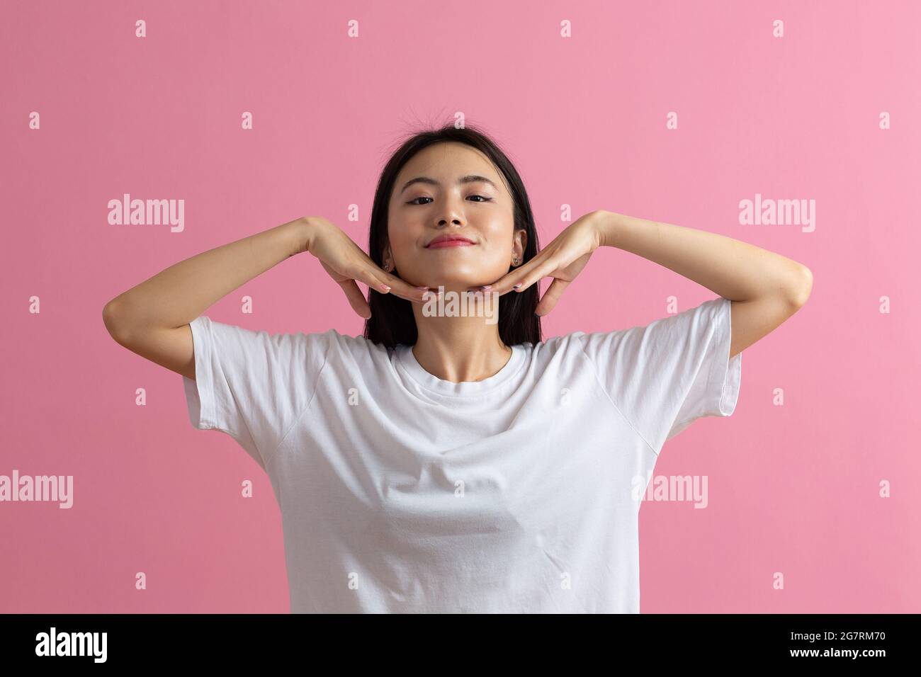 Close up portrait of young korean asian chinese woman doing facebuilding yoga face gymnastics yoga massage. Stock Photo
