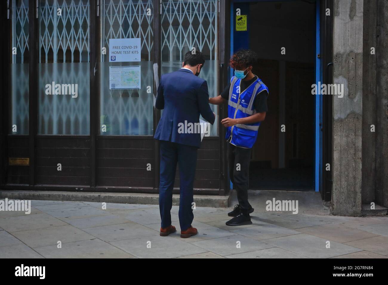 Londom (UK), 14 July 2021: An NHS support worker hands out covid self testing kits to members of the public on the streets of central London Stock Photo