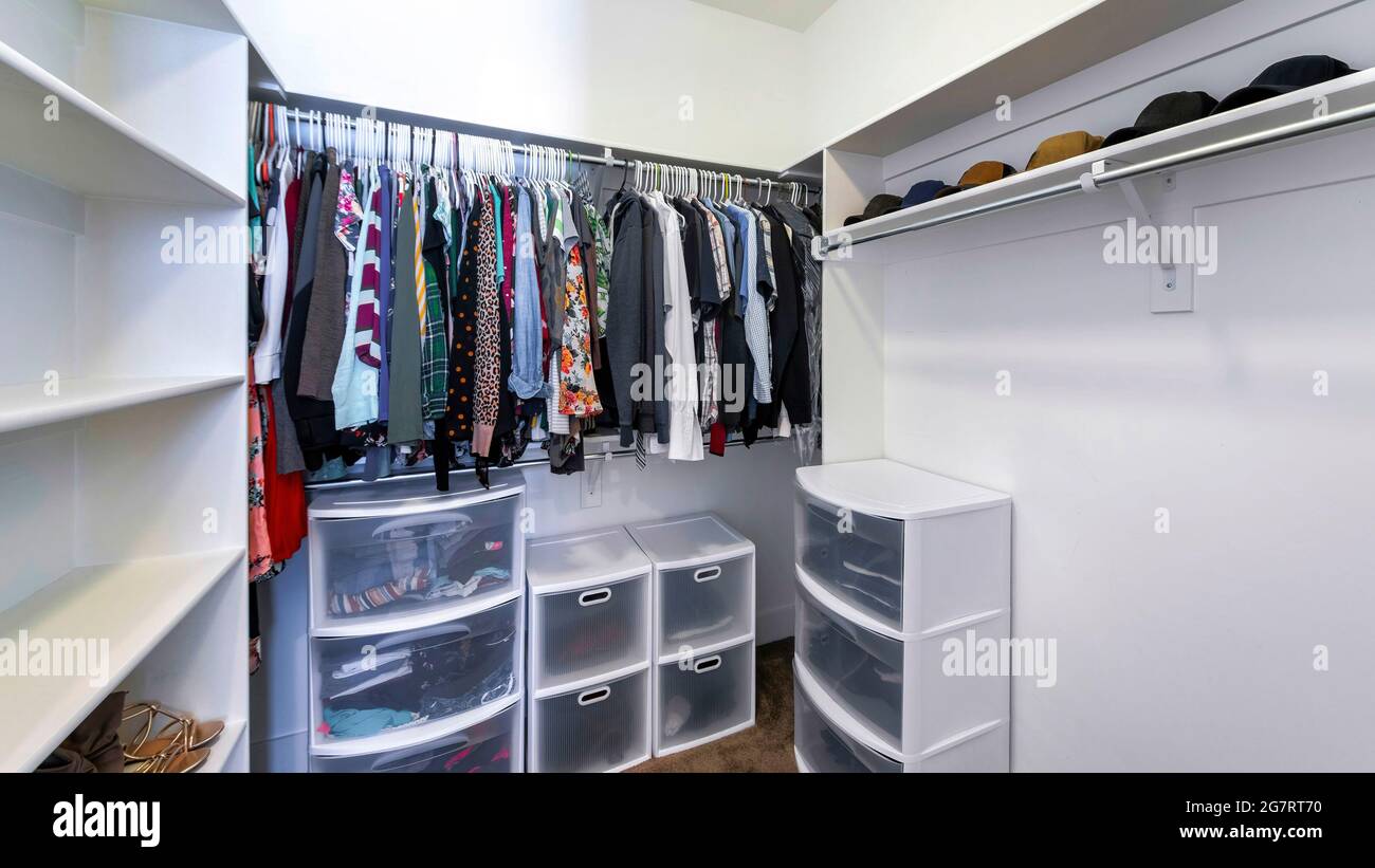 Pano Walk-in closet with plastic wardrobe storage and wall mounted shelves  and rods Stock Photo - Alamy