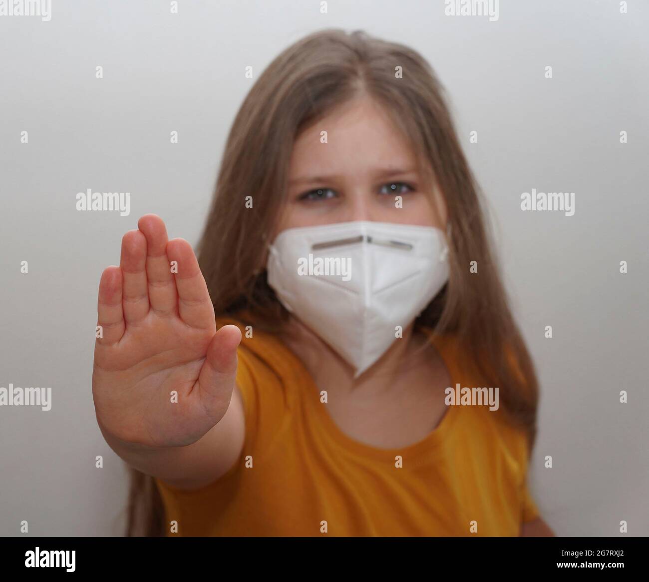 Influenza virus stop gesture. Girl in face mask show deny sign. Focus on a Hand only. The concept of preventing the spread of the pandemic. Stop the v Stock Photo