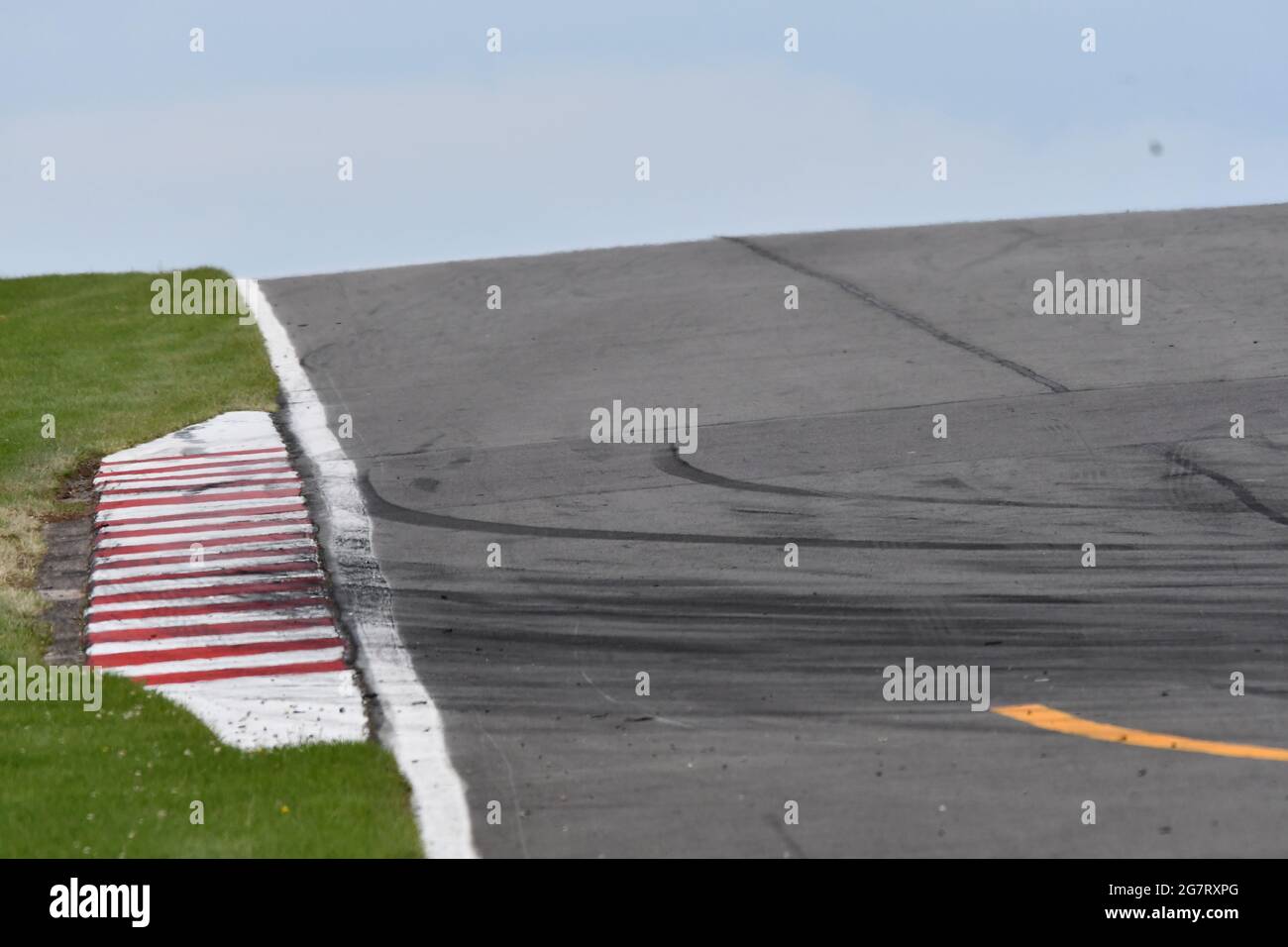 Part of a racetrack showing the rubber from the wheels as the cars have run onto the chevrons Stock Photo