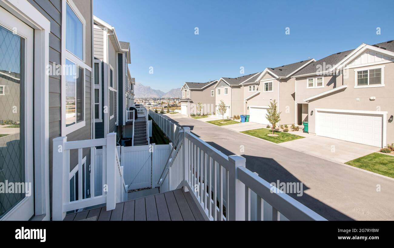Pano On top of the deck of a house with wood plank flooring and a view of neighbors' houses and garage Stock Photo