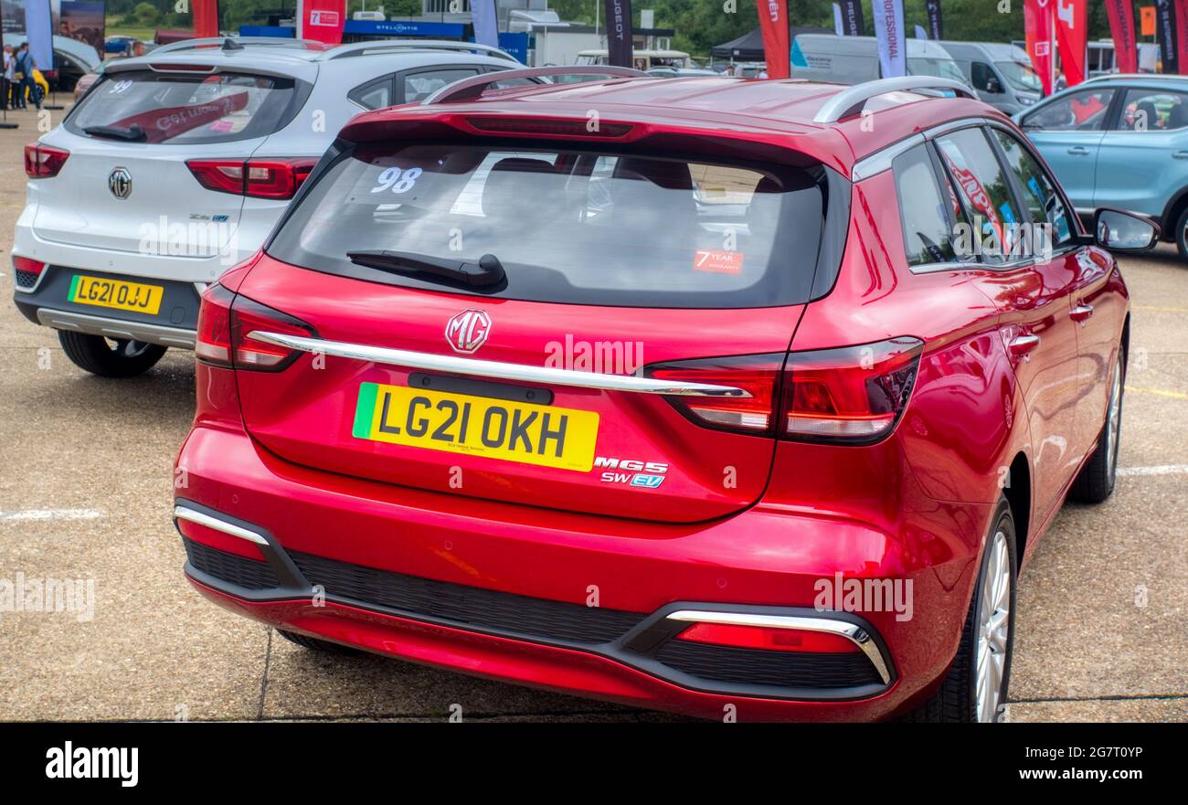 Electric MGs made by SAIC in China. An MG ZS EV in white (left) and an red MG 5 EV, Millbrook Proving Ground test track, Bedfordshire, UK Stock Photo