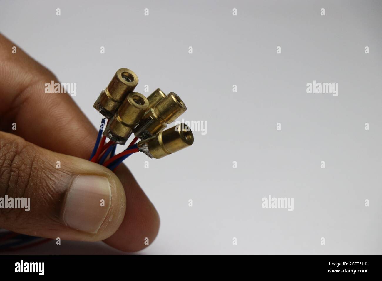 Group of copper case red dot laser diodes held in hand. Electronic