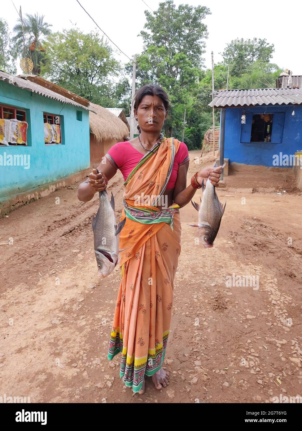 BHUBANESWAR, INDIA - Jun 25, 2021: tribal woman of the Odisha state of India with big carp fish in hand Stock Photo