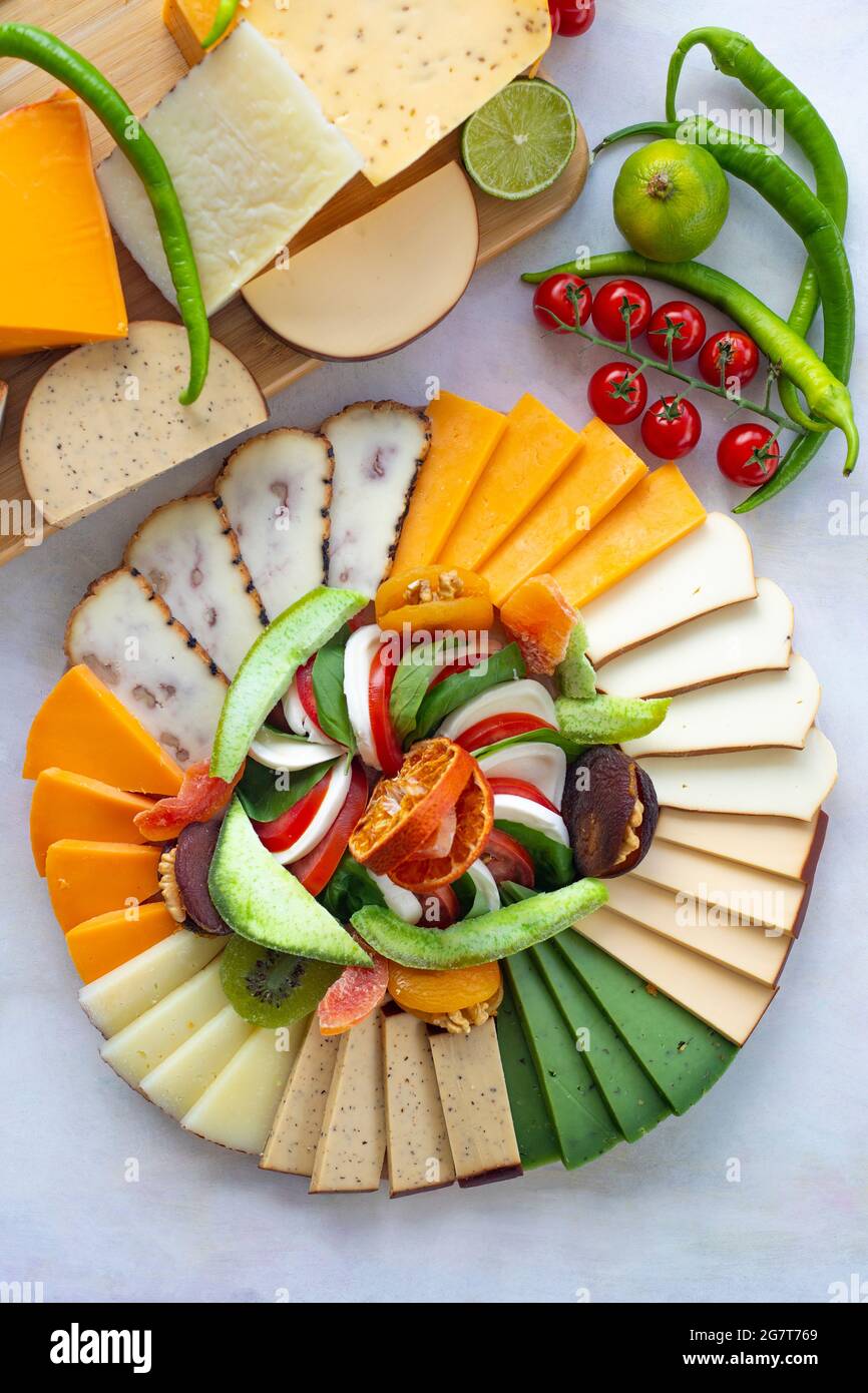 Cheese plate on a white wooden background. Cheese tasting platter. Types of cheese. Antipasto set platter. Cheese plate on table. top view Stock Photo