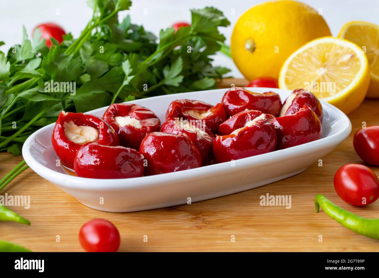 Cheese filled cherry peppers on wooden background Stock Photo