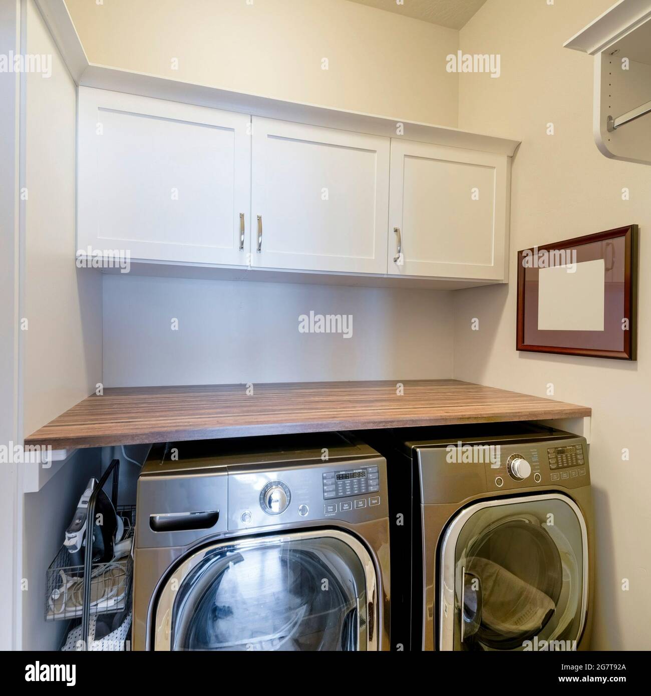 Square frame Laundry room with stainless laundry machines below the