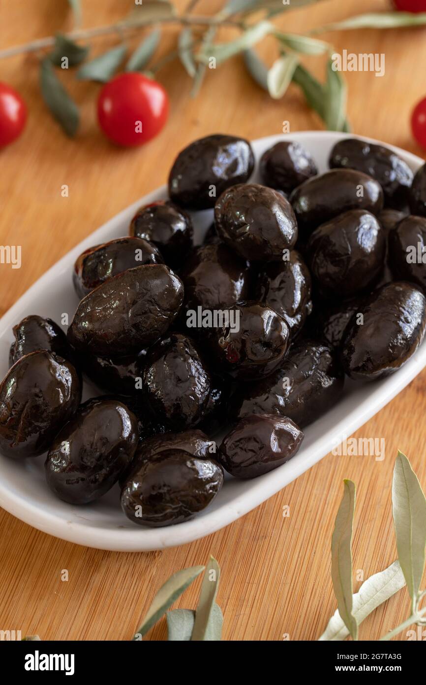 Black Kalamata olives. Tasty kalamata olives in the plate. Kalamata olives on wooden background Stock Photo